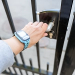 Personne ouvrant une grille avec une main.