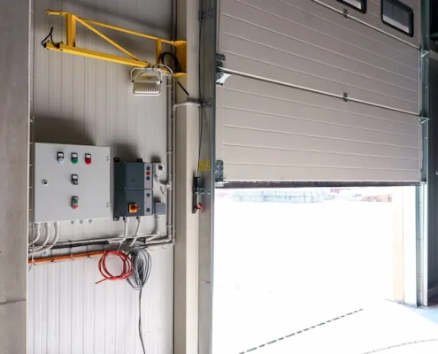 remplacement d’un moteur de porte de garage marseille Porte de garage ouverte avec panneaux de contrôle.