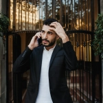 Homme appelant en costume devant porte.